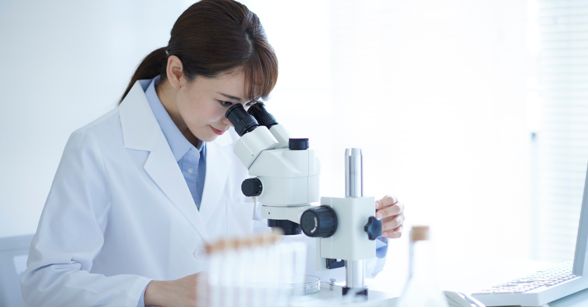 Laborantin im Labor mit einer Microscope